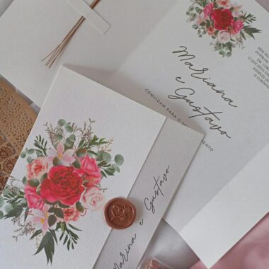 A beautifully styled wedding invitation with floral motifs and wax seal details.