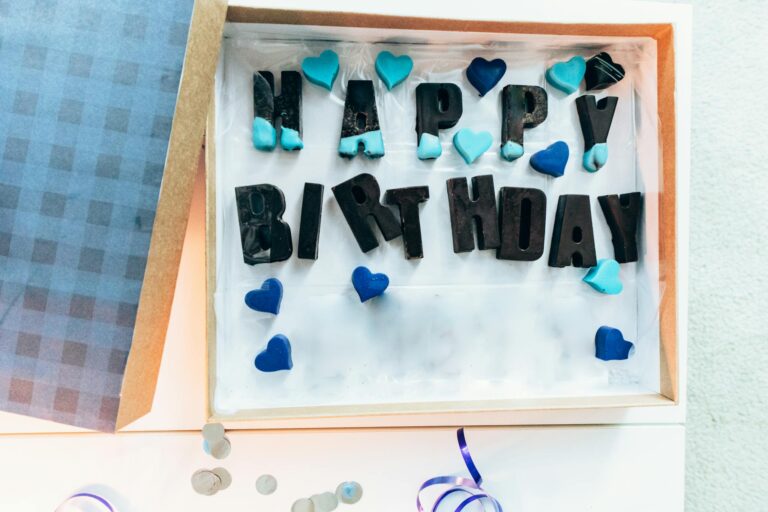 Top view of a birthday gift box with 'Happy Birthday' letters and blue heart decorations.